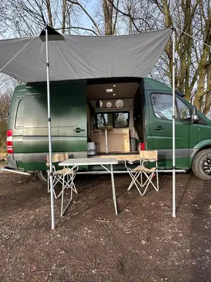 a green van with a tent on top of it at Mercedes Sprinter Camper Arbor in Heiloo