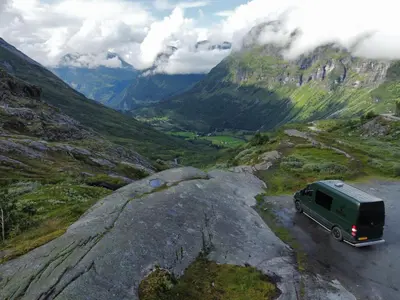 a green van driving down a mountain road at Mercedes Sprinter Camper Arbor in Heiloo