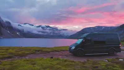 a van parked in a field next to a lake at Mercedes Sprinter Camper Arbor in Heiloo
