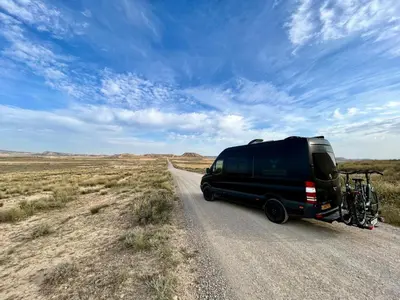 a black van driving down a road in the desert at Mercedes Sprinter Camper FREYA in Heiloo