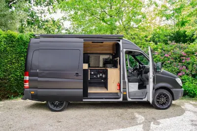 a grey van with its door open with a kitchen inside at Mercedes Sprinter Camper FREYA in Heiloo