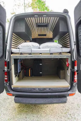 an open trunk of a truck with a bed in it at Mercedes Sprinter Camper FREYA in Heiloo
