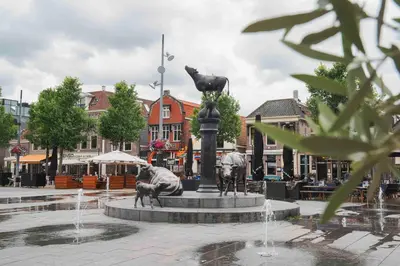 a fountain with a statue of a cat and a dog at Hotel Koemarkt in Purmerend