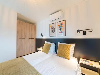 a bedroom with a large white bed with yellow pillows at Holiday home in 't Groene Hart on the water in Oud-Ade