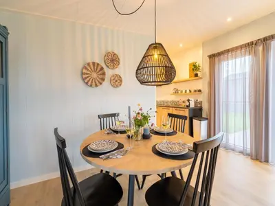 a dining room with a wooden table and chairs at Holiday home in 't Groene Hart on the water in Oud-Ade