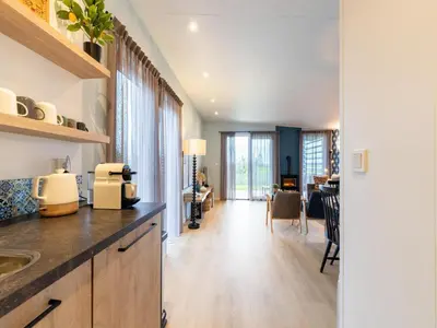 a kitchen with a counter and a dining room at Holiday home in 't Groene Hart on the water in Oud-Ade