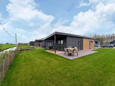 a small house with a table in a yard at Holiday home in 't Groene Hart on the water in Oud-Ade