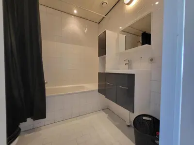 a bathroom with a tub and a sink and a mirror at Residenz Polderblick in Burgerbrug