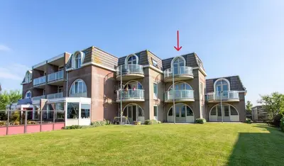 a large brick building with a lawn in front of it at Residenz Polderblick in Burgerbrug