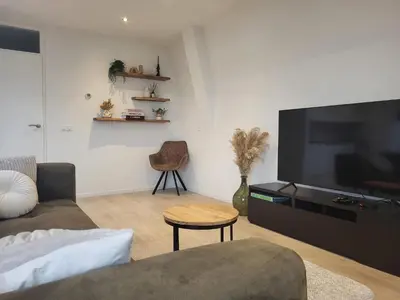 a living room with a large flat screen tv at Residenz Polderblick in Burgerbrug
