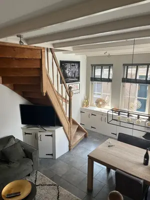 a living room with a staircase and a couch at De troeter in Monnickendam