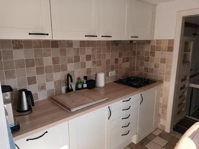 a kitchen with white cabinets and a counter top at De troeter in Monnickendam