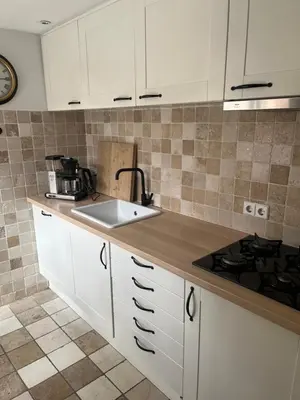 a kitchen with white cabinets and a sink at De troeter in Monnickendam