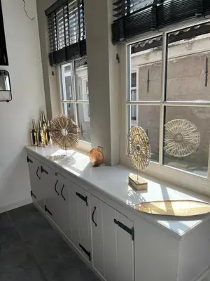 a white kitchen with windows and a counter with fan at De troeter in Monnickendam
