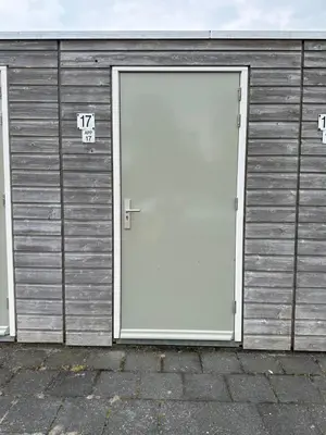 a large white door on a metal building at Appartement 'Zeeblick' in Burgerbrug