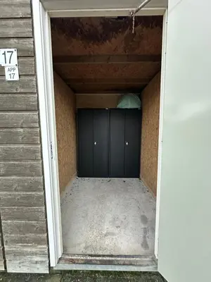 a garage with a black garage door in a house at Appartement 'Zeeblick' in Burgerbrug