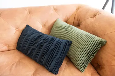 a brown couch with two pillows on it at Historic Canal House Apartment in Amsterdam