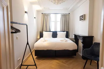 a bedroom with a bed and a desk and a chair at Historic Canal House Apartment in Amsterdam