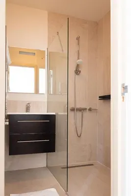 a bathroom with a shower with a glass door at Historic Canal House Apartment in Amsterdam