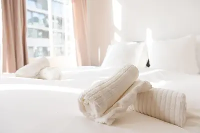 two beds with white sheets and towels on them at Historic Canal House Apartment in Amsterdam