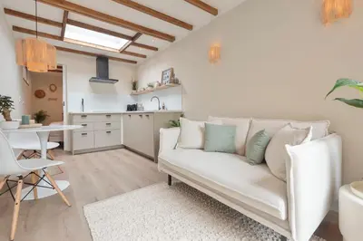 a living room with a couch and a kitchen at Beach House at C in Zandvoort