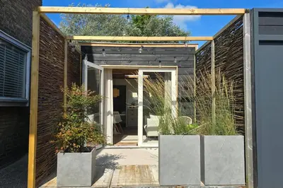 a glass extension to a house with a garden at Beach House at C in Zandvoort