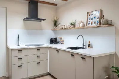 a kitchen with white cabinets and a sink at Beach House at C in Zandvoort