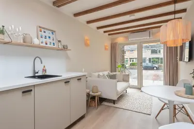 a kitchen and living room with a table and a couch at Beach House at C in Zandvoort