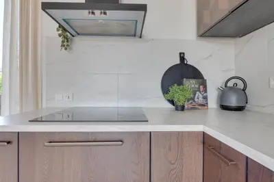 a kitchen with a sink and a counter top at Meerzicht 61 - Luxury 4 person apartment in Uitgeest