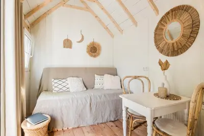a bedroom with a bed and a table and a mirror at Tiny house Zaandam in Zaandam