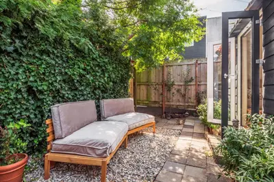 a couch sitting on a patio next to a fence at Tiny house Zaandam in Zaandam