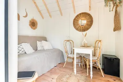 a bedroom with a bed and a table and chairs at Tiny house Zaandam in Zaandam