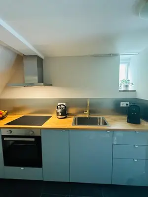 a kitchen with a sink and a stove at Souterrain Boslaan Katwijk aan zee in Katwijk aan Zee