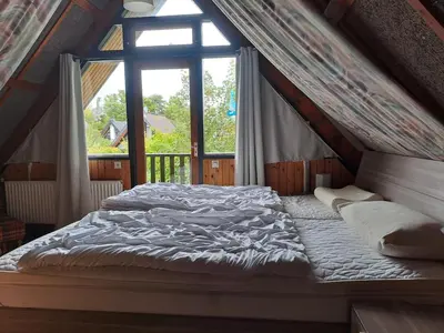 a bed in a room with a large window at Bungalowpark West Friesland in Opmeer