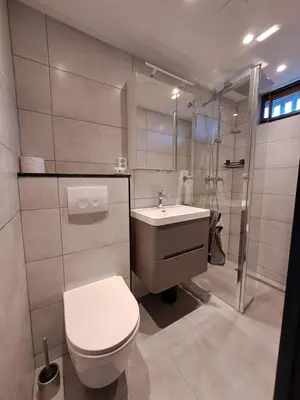 a bathroom with a toilet and a sink and a shower at Bungalowpark West Friesland in Opmeer