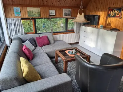 a living room with a couch and a table at Bungalowpark West Friesland in Opmeer