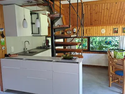 a kitchen with a white counter and a spiral staircase at Bungalowpark West Friesland in Opmeer