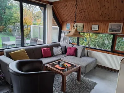 a living room with a couch and a table at Bungalowpark West Friesland in Opmeer