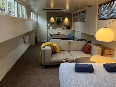 a living room with a couch and a table at Woonboot Josja in Amsterdam