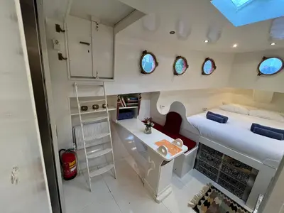 a small room with a bed and a desk at Woonboot Josja in Amsterdam
