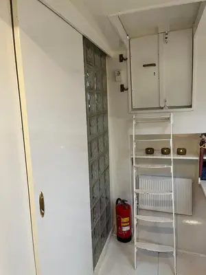 a room with a door and a shelf and a fire extinguisher at Woonboot Josja in Amsterdam