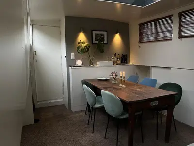 a dining room with a wooden table and blue chairs at Woonboot Josja in Amsterdam