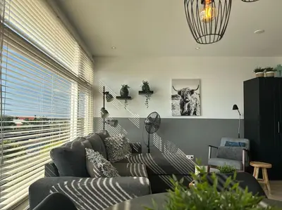 a living room with a couch and a large window at De schelp 71, Free parking in Zandvoort