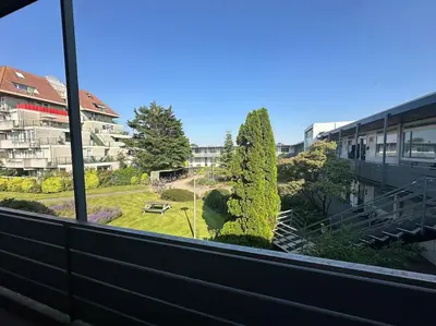 a view of a park from a window of a building at De schelp 71, Free parking in Zandvoort