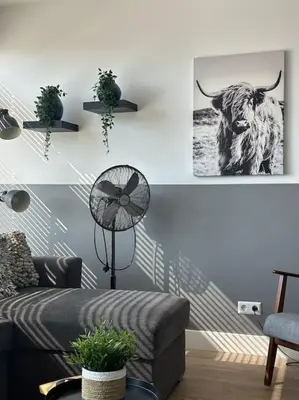 a living room with a cow picture on the wall at De schelp 71, Free parking in Zandvoort