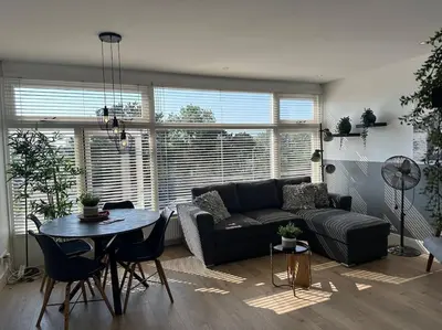 a living room with a couch and a table at De schelp 71, Free parking in Zandvoort