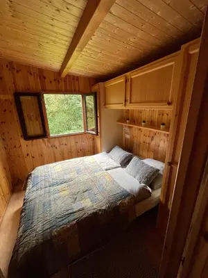a bedroom in a log cabin with a bed in it at De Meerkoet in Nieuwe-Niedorp