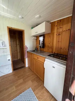 a kitchen with a stove and a white refrigerator at De Meerkoet in Nieuwe-Niedorp