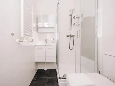 a white bathroom with a shower and a toilet at Bella Cottage Zandvoort in Zandvoort
