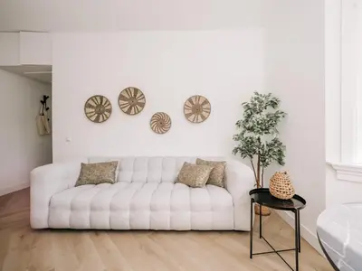 a white living room with a white couch and a table at Bella Cottage Zandvoort in Zandvoort